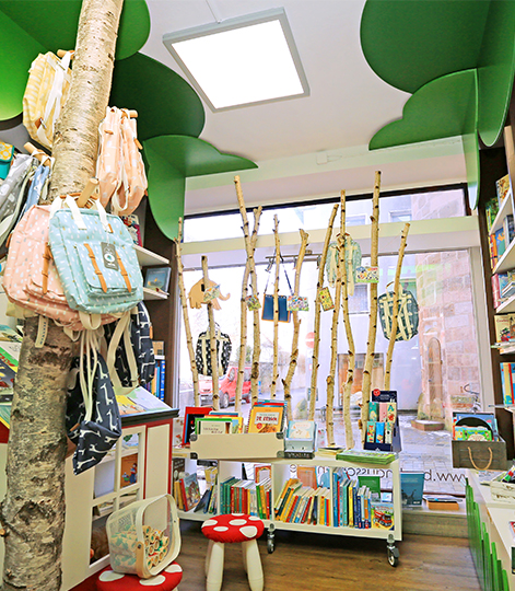Kinderecke der Buchhandlung am Färberturm mit dünnen Baumstämmen und Stühlen in Pilzoptik