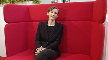Trendexpertin Gabriela Kaiser sitzt auf einem roten Sofa zum Interview